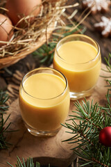 Two glasses of Eiecognac with fresh eggs and Christmas decoration