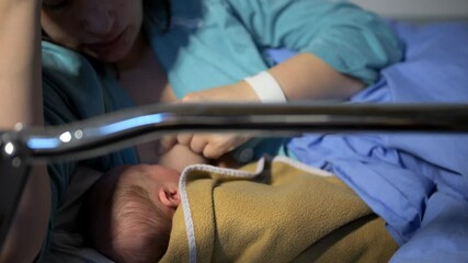 Close up shot of proud mother caressing newborn baby at hospital