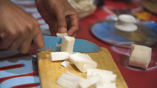 Cassava is cut with a kitchen knife, peeled and looks clean and white.