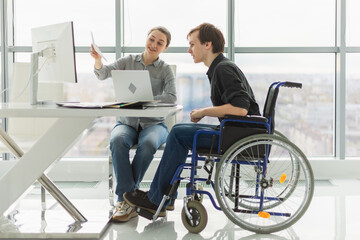 Colleagues business people woman man in chair for people with disability working on office. Startup...