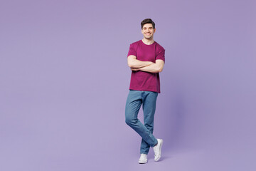 Full body young smiling happy Caucasian man wear violet t-shirt casual clothes hold hands crossed...