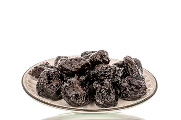 Sweet prunes in a ceramic bowl, macro, isolated on a white background.