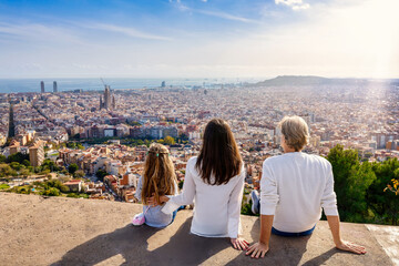 A family enjoys the panoramic view of the skyline of Barcelona, Spain, during their city trip vacation