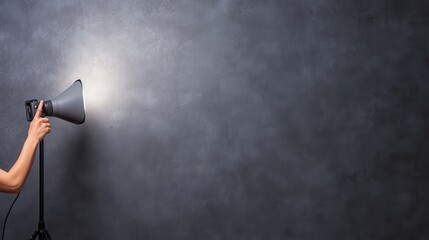 A person holds a megaphone against a textured wall, symbolizing communication, announcement, or motivation.