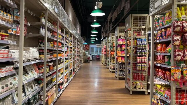 Empty supermarket aisle nobody with various products on shelves.
