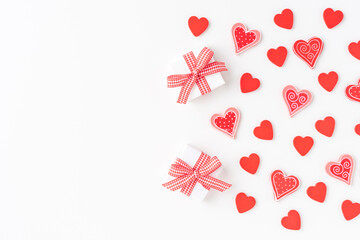 Cute red hearts and gift boxes on white background with copyspace. Top view