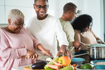 Happy black family cooking inside kitchen at home - Daughter, son, father and mother having fun...