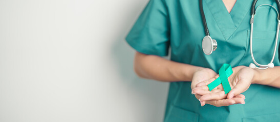 Doctor holding Teal Ribbon for January Cervical Cancer Awareness month. Uterus and Ovaries, Cervix,...