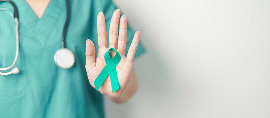 Doctor holding Teal Ribbon for January Cervical Cancer Awareness month. Uterus and Ovaries, Cervix, Endometriosis, Hysterectomy, Uterine fibroids, Reproductive, Healthcare and World cancer day