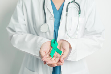 Doctor holding Teal Ribbon for January Cervical Cancer Awareness month. Uterus and Ovaries, Cervix, Endometriosis, Hysterectomy, Uterine fibroids, Reproductive, Healthcare and World cancer day