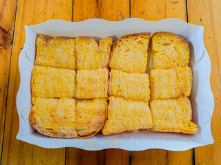 Grilled butter toast, golden brown crispy bread topped with sugar and sweetened condensed milk.