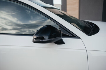 Fototapeta premium A compact, modern and stylish family wagon in white, with beautiful wheels, a large black radiator grille and body elements.
