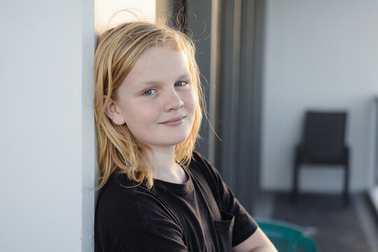 Pre-teen boy leaning against wall on balcony of high rise building on the Gold Coast