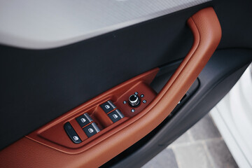 Obraz premium Modern brown car interior, leather steering wheel, climate control, navigation, air ducts, deflectors on the car panel, interior details.