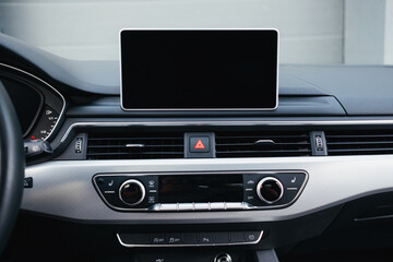 Modern brown car interior, leather steering wheel, climate control, navigation, air ducts, deflectors on the car panel, interior details.