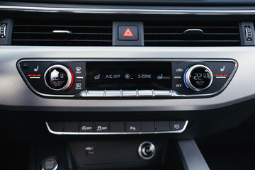 Modern brown car interior, leather steering wheel, climate control, navigation, air ducts, deflectors on the car panel, interior details.