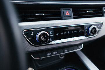 Modern brown car interior, leather steering wheel, climate control, navigation, air ducts, deflectors on the car panel, interior details.