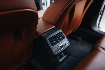 Obraz premium Modern brown car interior, leather steering wheel, climate control, navigation, air ducts, deflectors on the car panel, interior details.