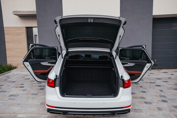 Modern brown car interior, leather steering wheel, climate control, navigation, air ducts, deflectors on the car panel, interior details.