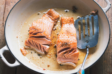 Salmon fried in oil on pan 