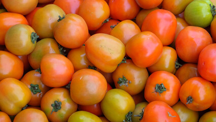 Abstract pattern and shape of pile of fresh red tomatoes. Pile of ripe tomatoes at a traditional market. Natural pattern and texture background for graphic design. Related to agricultural industry art