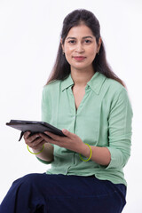 Confident woman holding digital tablet over white background