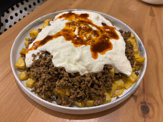 Turkish food Cokertme Kebab Beef meat kebab with yoghurt and french fries.