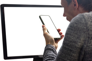 Angry man having problem with computer and talking on phone with technical support. Close-up of man using computer and smartphone, seen from behind, white screen for copy space