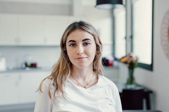 Head shot portrait serious beautiful young woman with perfect smooth skin looking at camera, standing at home, profile picture, focused attractive girl shooting video, recording vlog, job interview.