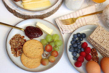 Assortment of various breakfast foods and drinks on the white table. Selective focus.