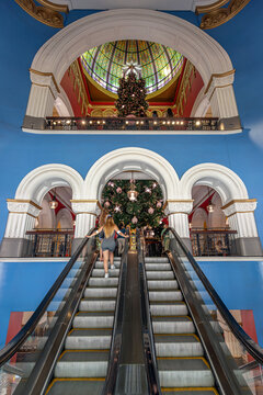 Unrecognisable people on the escalators leading up to foyer and Christmas tree at the Queen Victoria Building in Sydney, Australia. Photo taken in November 2024. 