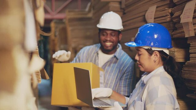 African man worker and asian woman recheck stock at paper factory.
