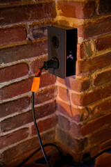 black industrial outlet in adobe wall