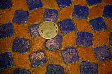 bronze drain cover on rustic floor