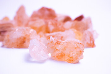 A pile of pink rocks on a white background. The rocks are of different sizes and shapes, and they appear to be arranged in a random pattern. 