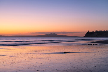 Majestic sunrise over the Rangitoto Island as view from Long Bay, Auckland, New Zealand