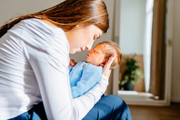 Tender moment between mother and newborn infant at home