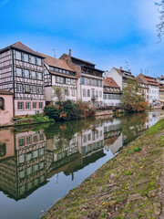 Picturesque river view in La Petite France in Strasbourg with half-timbered houses and water reflection, Colourful architecture, canal and blue sky in November, Travel destination, Alsace, France
