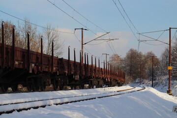 Cargo train on rails in winter with snow