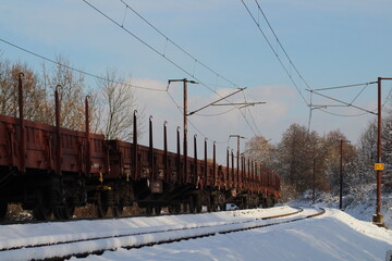 Cargo train on rails in winter with snow