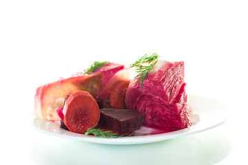 pickled cabbage with beets and carrots, in a plate, isolated on white background