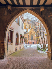 Fototapeta premium Passage street view to The Église Saint-Martin (St. Martin church)&nbsp;in snow, Colmar cathedral, Christmas mood in November, Colmar, Alsace, France