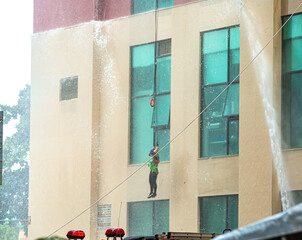 A man is lowered on a rope during a rescue operation by firefighters