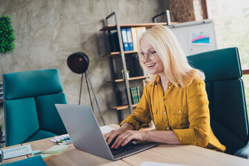 Photo of cheerful positive lady broker dressed eyewear chatting modern gadget indoors workplace...