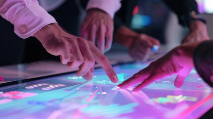 Close-up of a business team鈥檚 hands working together on a project, using a shared touchscreen table displaying a collaborative digital whiteboard with flowcharts and diagrams