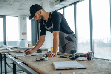 Writing on the paper. A man is renovating an unfinished room