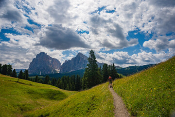 Beautiful hiking trail in the Dolomites of Italy under a dramatic sky with lush green fields