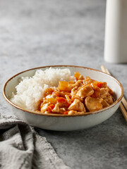 bowl of boiled rice with chicken sweet and sour sauce