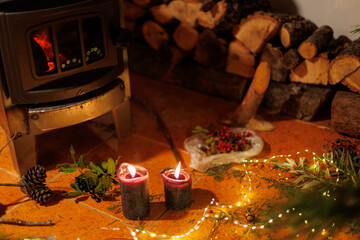 Christmas and winter mood. stove and cozy home decor. the candles are burning.  Holiday decoration.