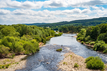View from Hexham Bridge of Man Fishing in the River Tyne near Hexham, UK